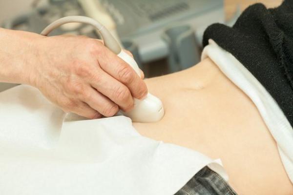 0 mid adult woman having abdominal ultrasound