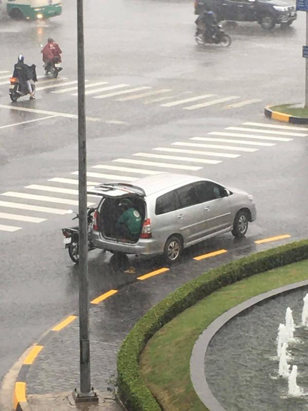Góc đáng yêu: Bác tài ô tô mở cốp xe để tài xế Grab ngồi trú tạm giữa trời mưa to Góc đáng yêu: Bác tài ô tô mở cốp xe để tài xế Grab ngồi trú tạm giữa trời mưa to